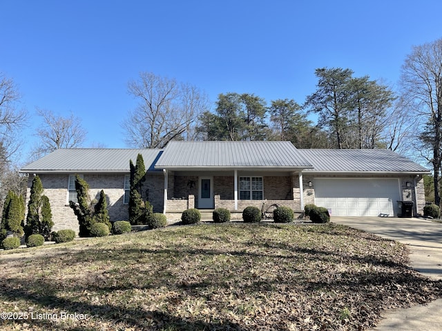 ranch-style house with concrete driveway, a garage, and metal roof