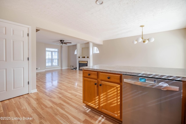 kitchen with decorative light fixtures, a textured ceiling, open floor plan, light wood-style floors, and dishwasher