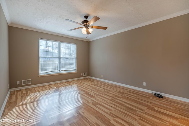 empty room featuring visible vents, ornamental molding, a ceiling fan, a textured ceiling, and light wood-style floors