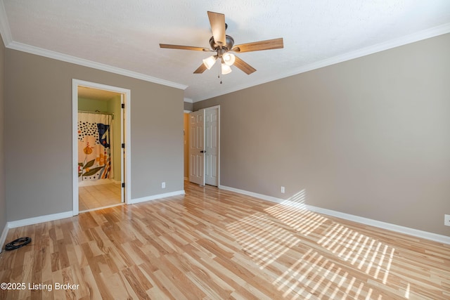 unfurnished bedroom featuring light wood-type flooring, baseboards, ceiling fan, and crown molding