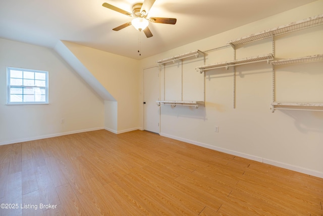 bonus room with a ceiling fan, baseboards, and light wood-type flooring