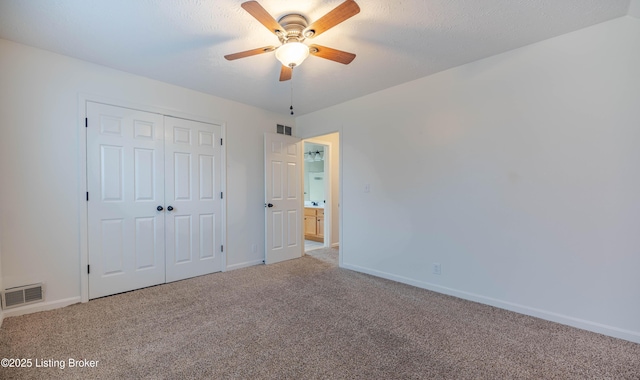 unfurnished bedroom featuring a closet, visible vents, baseboards, and carpet