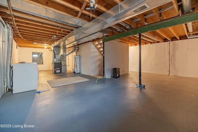 unfinished below grade area featuring water heater, heating unit, washer / clothes dryer, and visible vents