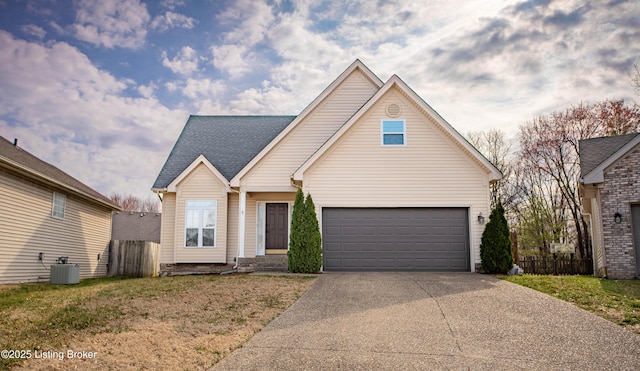 traditional-style house with fence, central air condition unit, a front yard, a garage, and driveway