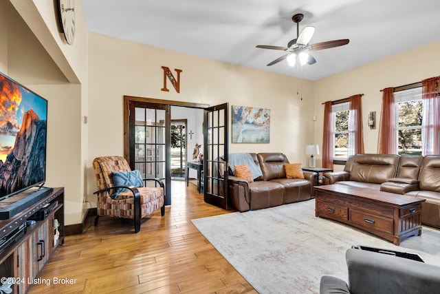 living room with light wood-style flooring, a ceiling fan, and french doors
