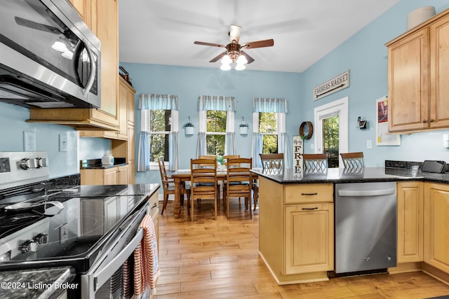 kitchen with light brown cabinets, appliances with stainless steel finishes, light wood-style floors, and ceiling fan