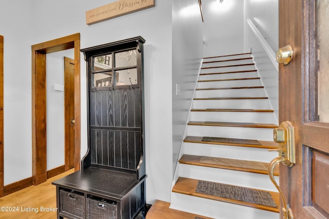 staircase featuring baseboards and wood finished floors