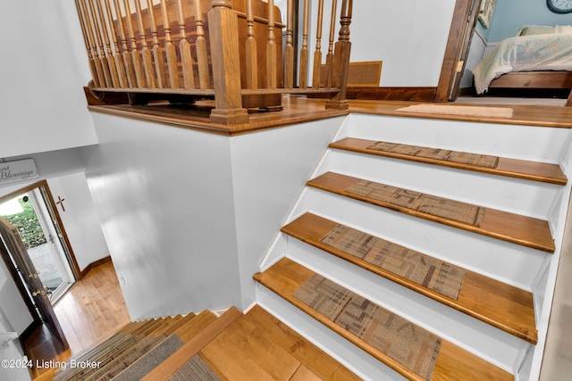 stairway featuring baseboards and hardwood / wood-style flooring