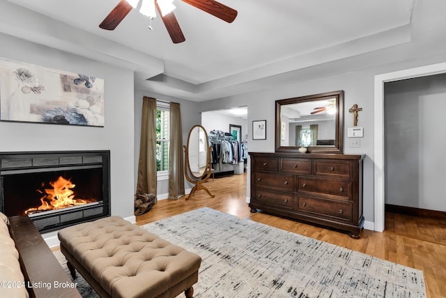 bedroom with a spacious closet, baseboards, light wood-type flooring, and a closet