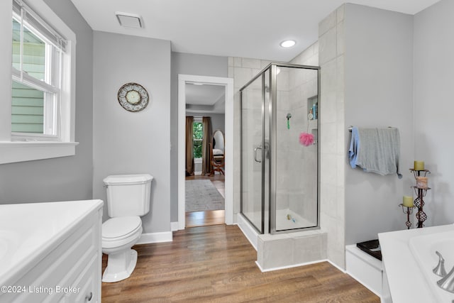 full bath featuring toilet, a stall shower, wood finished floors, baseboards, and a bath