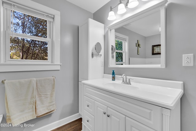 bathroom with vanity, wood finished floors, and baseboards