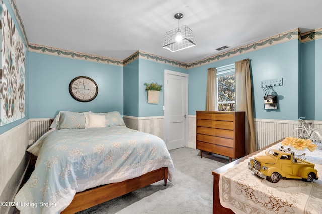 bedroom with visible vents, wainscoting, and carpet floors