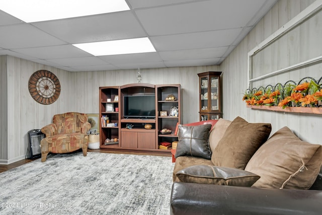 living room featuring a drop ceiling and wood finished floors