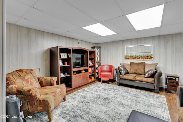 living room featuring wood finished floors and a paneled ceiling