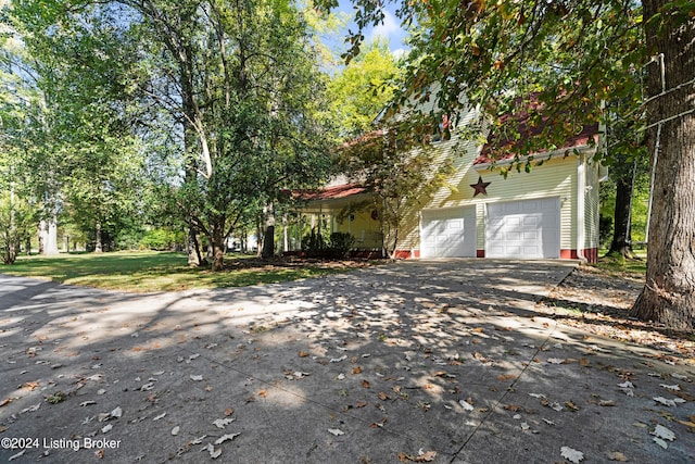 obstructed view of property featuring concrete driveway and a garage