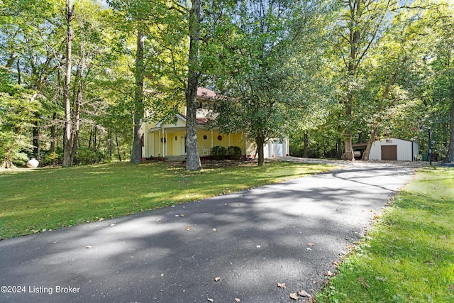 view of front of property featuring a front lawn, an attached garage, and driveway