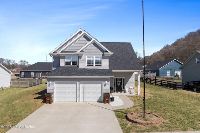 view of front of home with a front lawn, concrete driveway, fence, and a garage