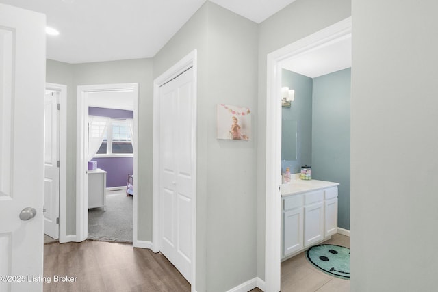 bathroom with baseboards, wood finished floors, and vanity