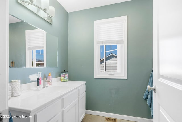 bathroom with vanity, wood finished floors, visible vents, and baseboards