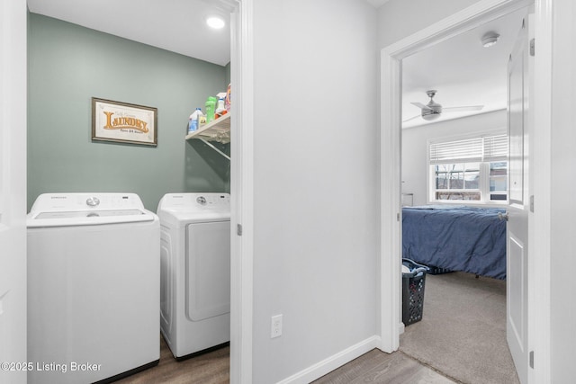 clothes washing area featuring independent washer and dryer, wood finished floors, baseboards, ceiling fan, and laundry area