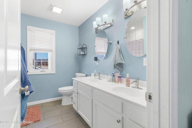 full bathroom with a sink, baseboards, toilet, and double vanity