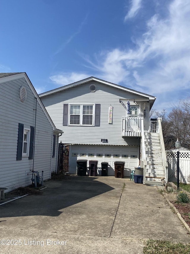 view of property exterior with stairway, concrete driveway, and a garage