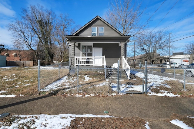 shotgun-style home with a fenced front yard, a porch, and a gate