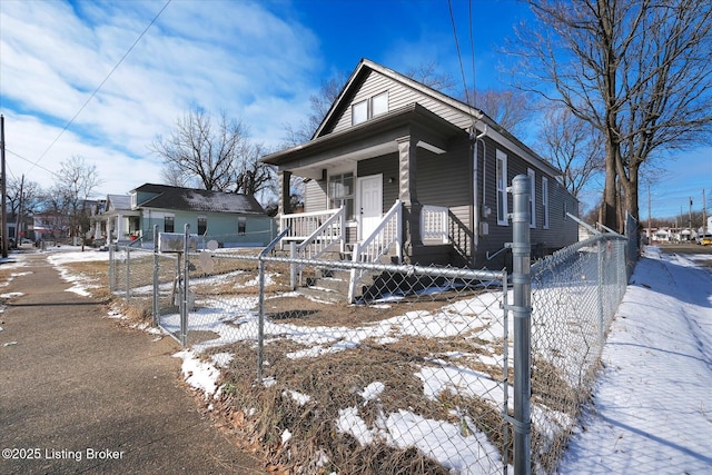 shotgun-style home featuring a fenced front yard, a porch, and a gate