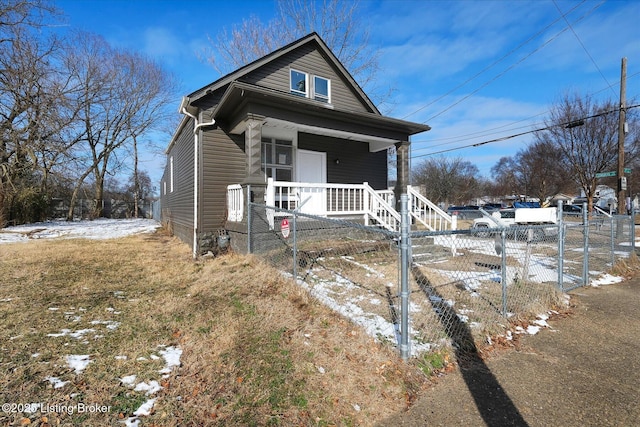 shotgun-style home with a gate, covered porch, and fence