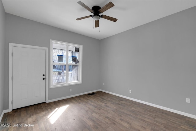 empty room with baseboards and wood finished floors