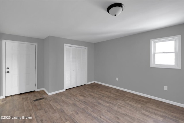 unfurnished bedroom with baseboards and wood finished floors