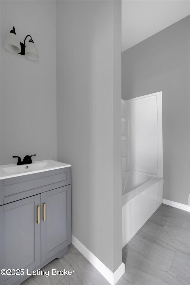 full bathroom featuring baseboards and vanity