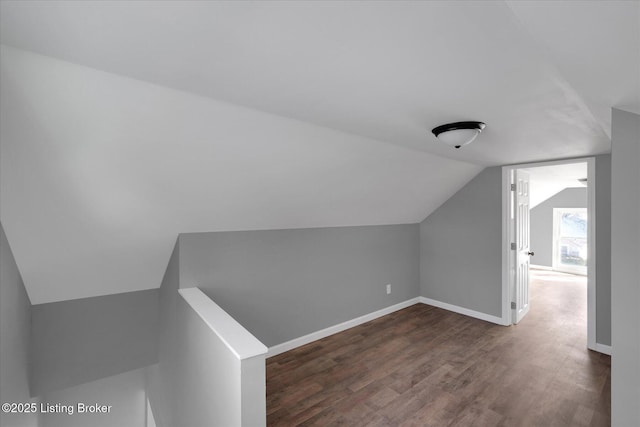 bonus room with lofted ceiling, baseboards, and dark wood-style flooring