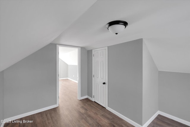 additional living space featuring vaulted ceiling, baseboards, and wood finished floors