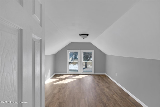 bonus room featuring baseboards, lofted ceiling, and wood finished floors