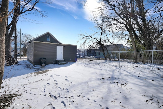 snow covered property with entry steps and fence