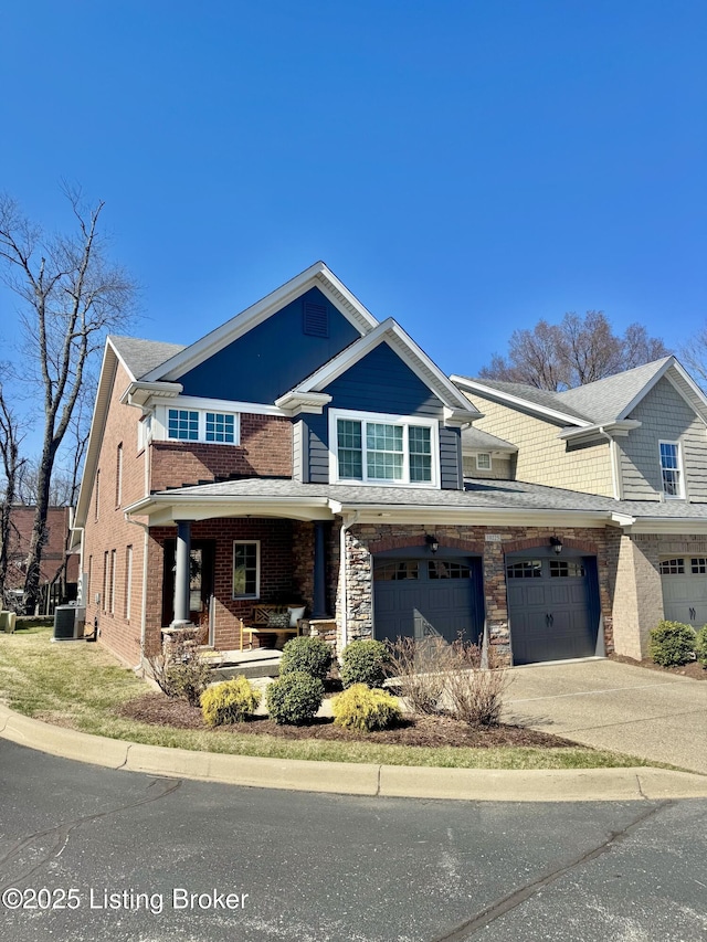 view of front of home featuring driveway, stone siding, a porch, central AC, and an attached garage