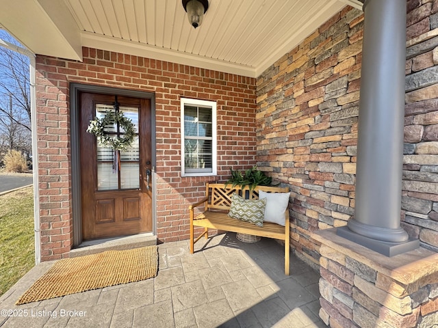 view of exterior entry featuring brick siding