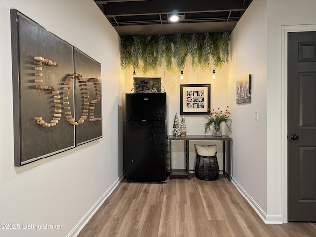 hallway with baseboards and wood finished floors