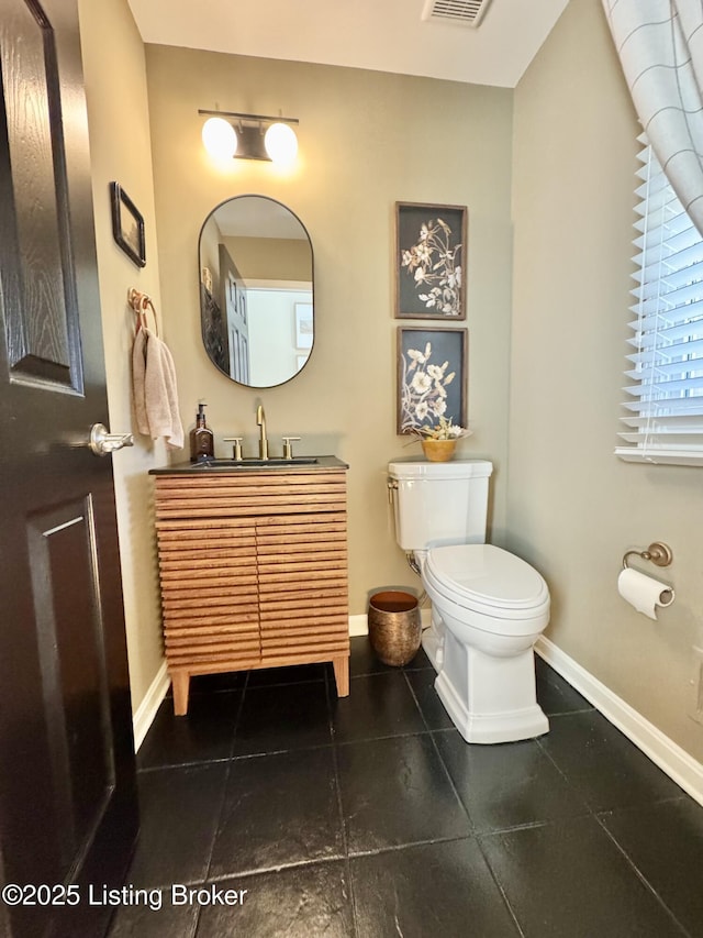 bathroom featuring vanity, visible vents, baseboards, tile patterned floors, and toilet