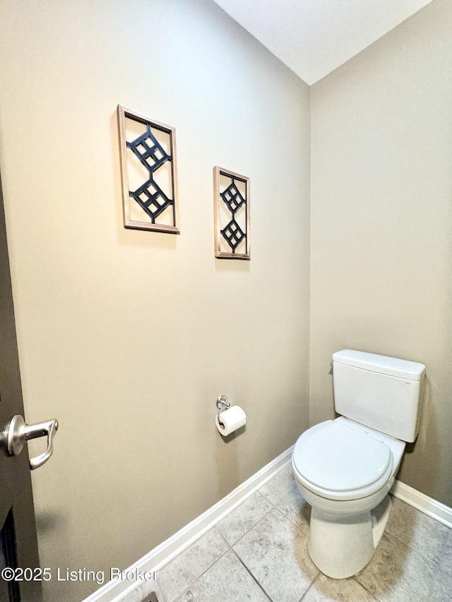 bathroom with tile patterned flooring, toilet, and baseboards