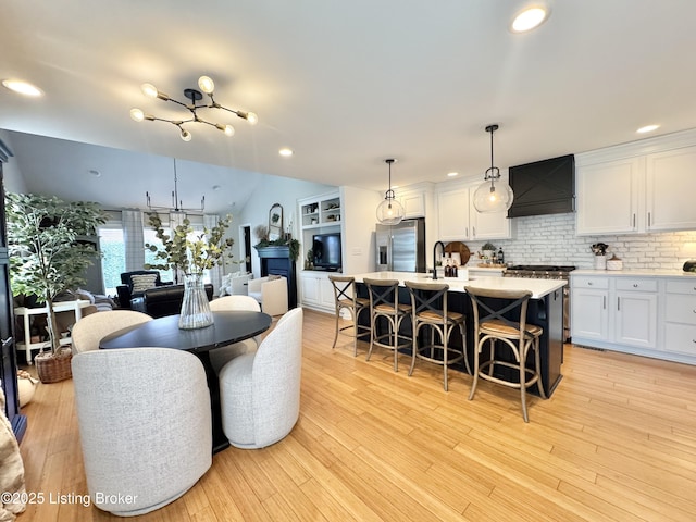 dining space with light wood finished floors and recessed lighting