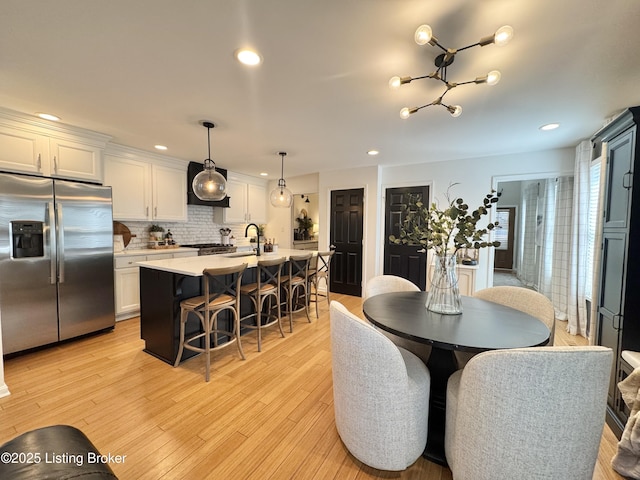 dining area featuring light wood-style flooring and recessed lighting