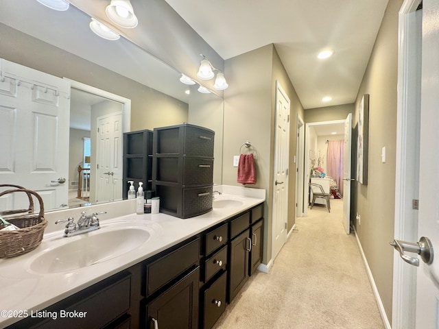 full bath with double vanity, recessed lighting, baseboards, and a sink