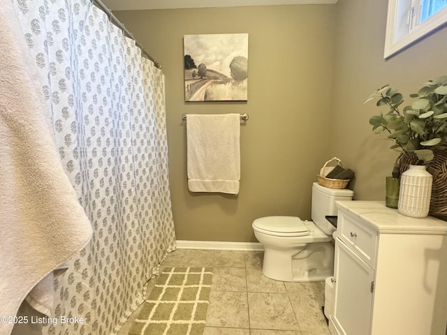 bathroom with tile patterned floors, toilet, a shower with shower curtain, and baseboards