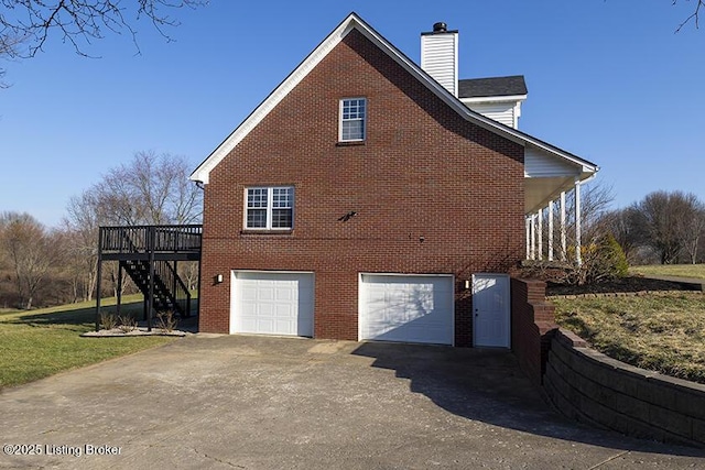 view of property exterior with driveway, a chimney, stairs, a garage, and brick siding