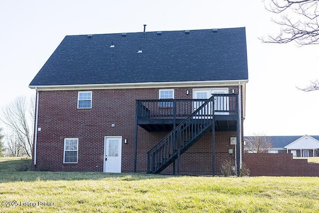 rear view of house with brick siding, a deck, stairs, and a yard