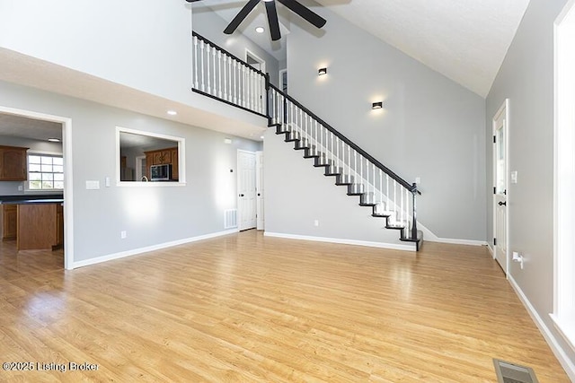 unfurnished living room featuring stairway, baseboards, visible vents, and light wood-type flooring