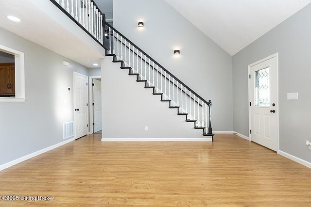 foyer featuring visible vents, stairway, baseboards, and light wood-style floors