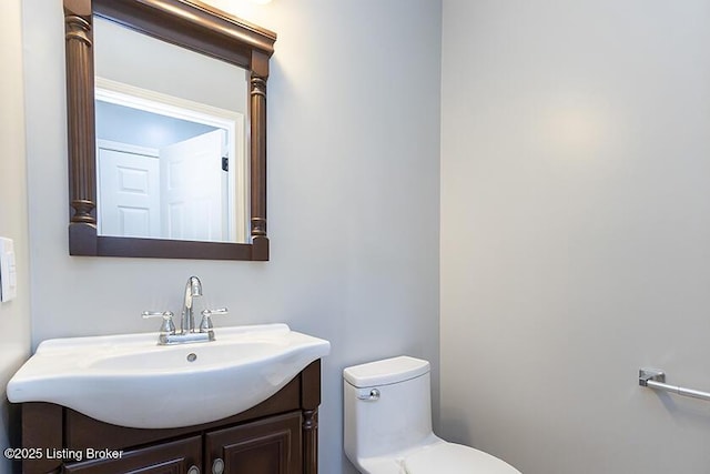 half bathroom with vanity and toilet